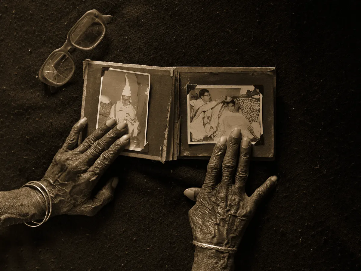 Grandmother's hands resting on an old black-and-white wedding album