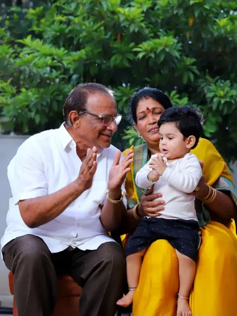 Grandparents laughing with their grandson on the grandmother's lap